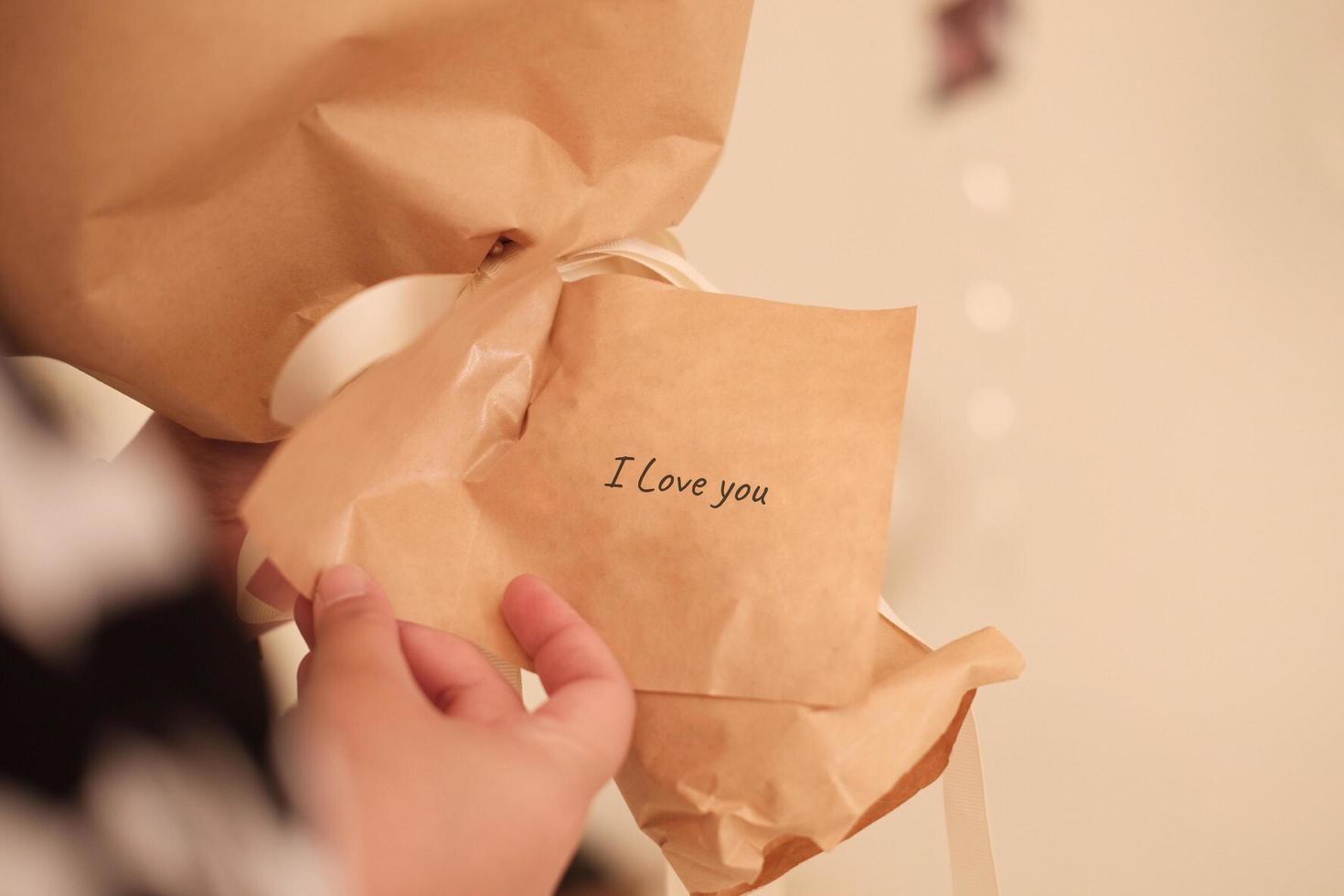 i love you - inspirational handwriting on flower wrapping paper with hand holding photo