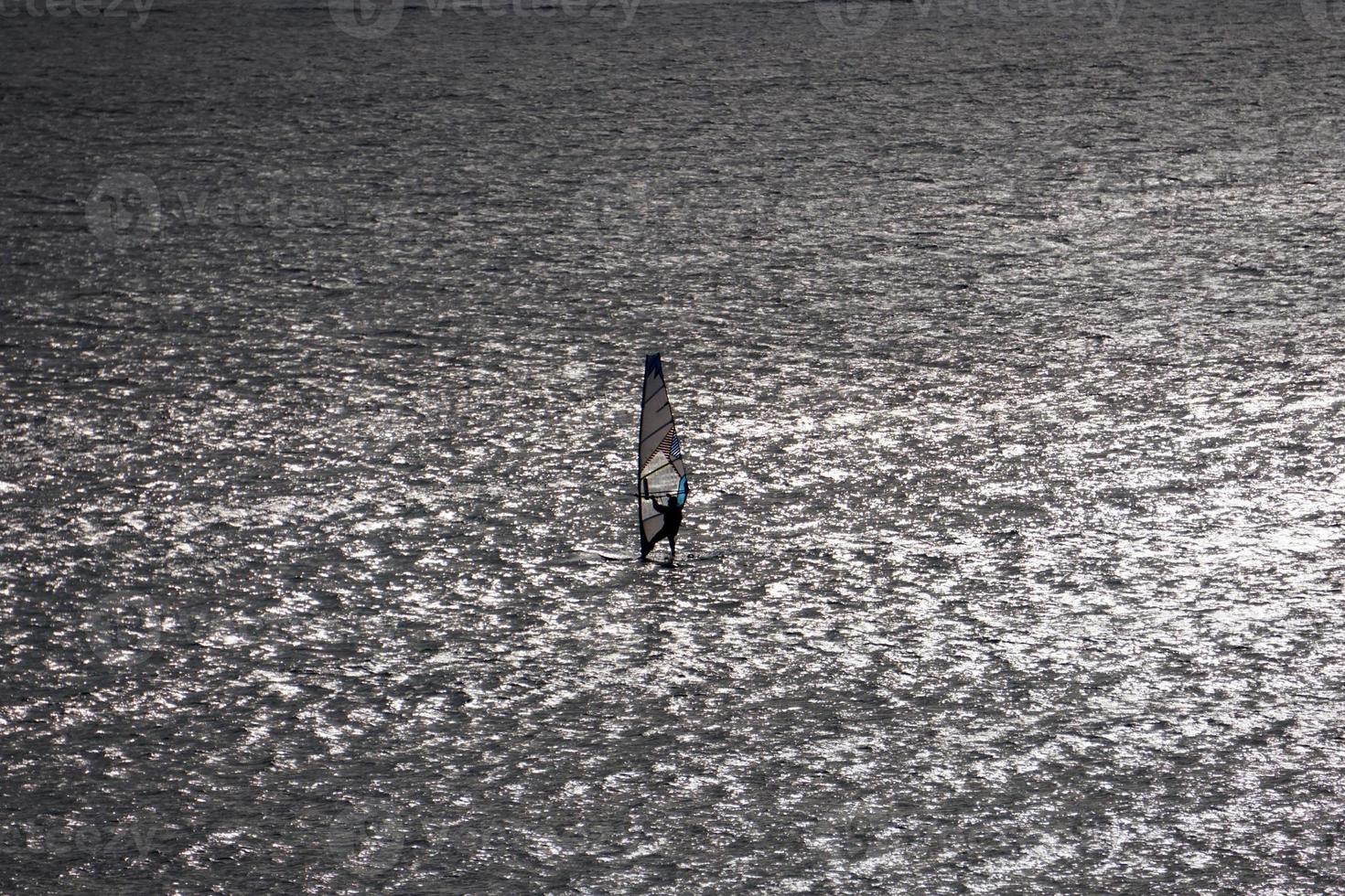 Windsurfer silhouette on the backlight photo