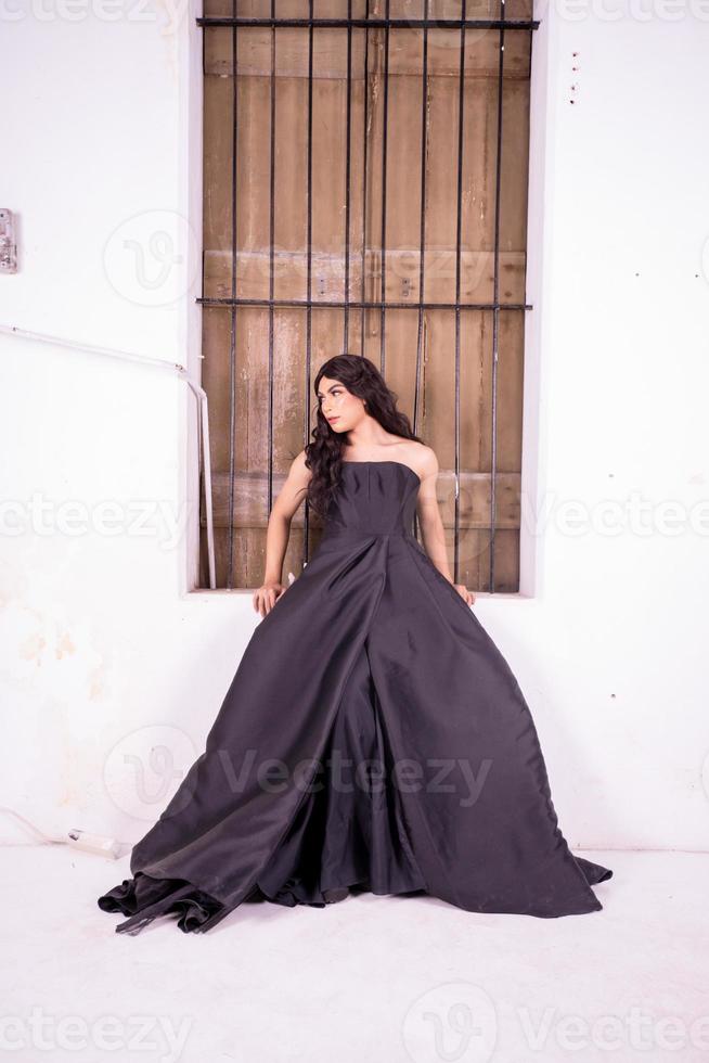 Asian woman standing in the wooden window while wearing a black dress photo