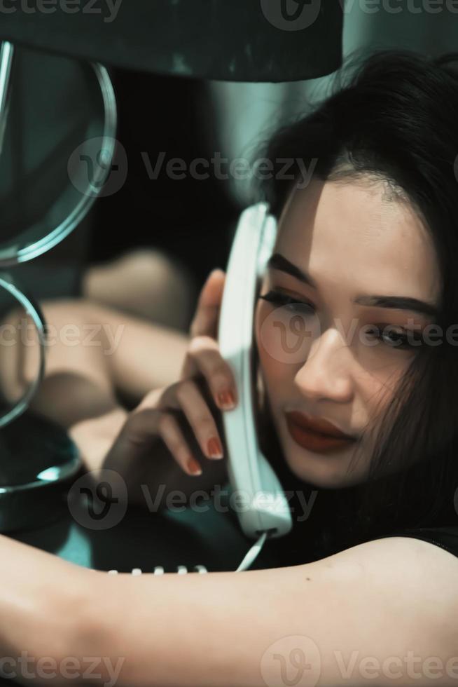 una mujer sostiene un teléfono y se lo pone en la oreja mientras llama a la policía foto