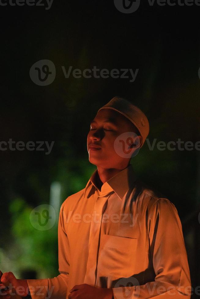 A Muslim man lighten up the campsite with the fire torch in his hands photo