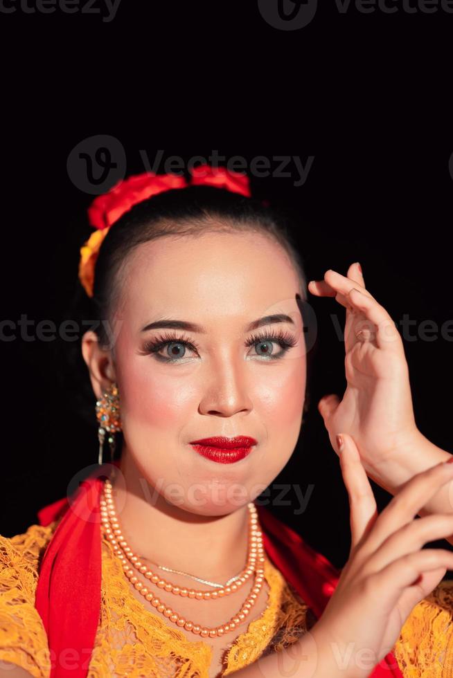 mujer indonesia maquillada con labios rojos usando un collar dorado y aretes dorados foto