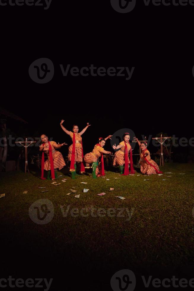 Javanese dancers with beautiful makeup and traditional costume while dancing the traditional dance on the stage photo