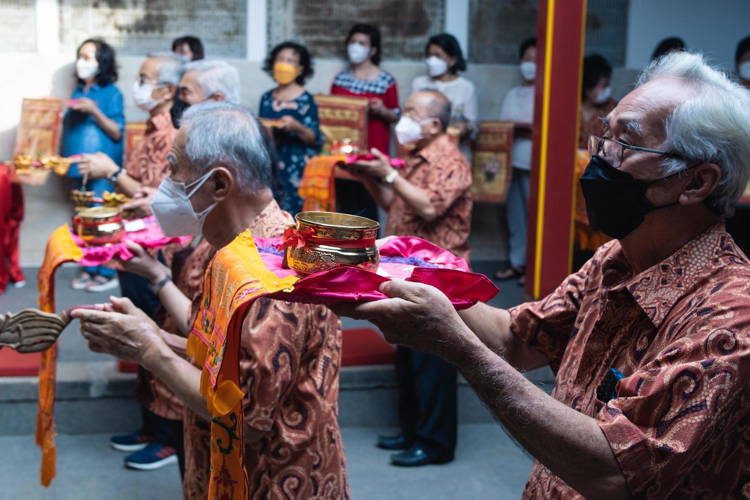Bandung City, Indonesia, 2022 - The congregation and the monks standing together while praying at the altar to respect the god photo