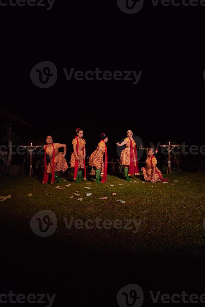 bailarines javaneses con hermoso maquillaje y traje tradicional mientras bailan la danza tradicional en el escenario foto
