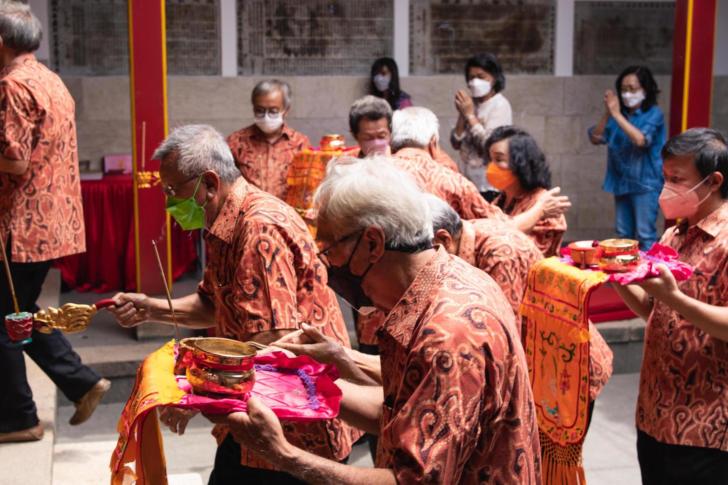 Bandung City, Indonesia, 2022 - The man united together for brings the offering to the monks and god on the altar while praying photo