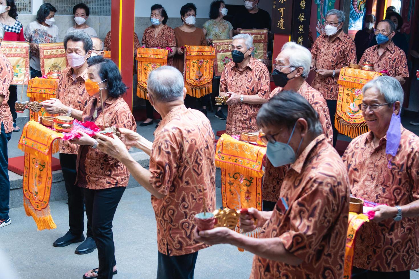 Bandung City, Indonesia, 2022 - The congregation and the monks standing together while praying at the altar to respect the god photo