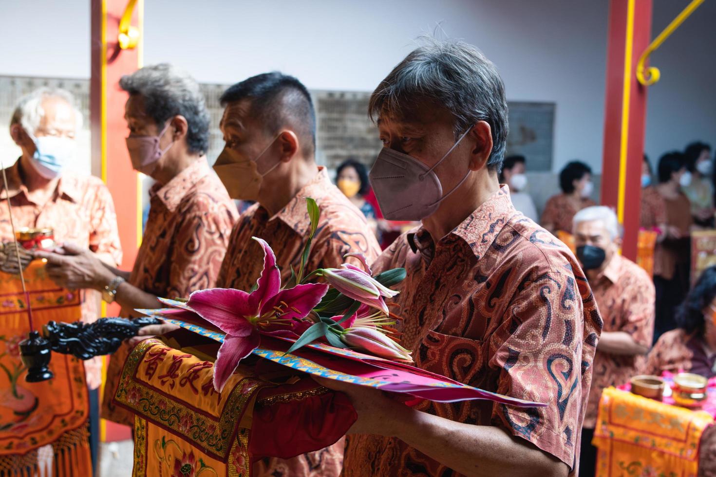 Bandung City, Indonesia, 2022 - The congregation and the monks standing together while praying at the altar to respect the god photo