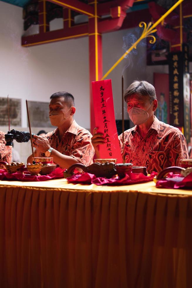 Bandung City, Indonesia, 2022 - The visitor praying together with the monks in front of the offerings to the god photo