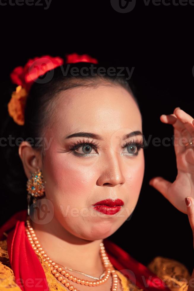 Exotic Javanese woman wearing beautiful makeup with red lips while wearing a traditional yellow costume and red scarf photo