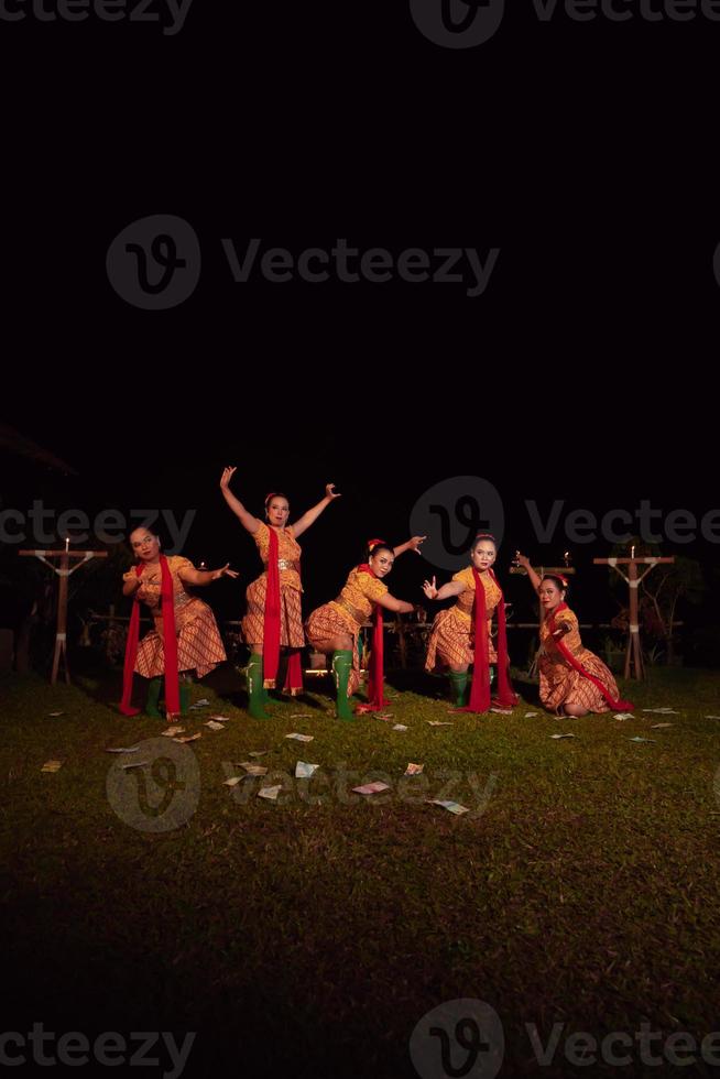 Javanese dancers with beautiful makeup and traditional costume while dancing the traditional dance on the stage photo