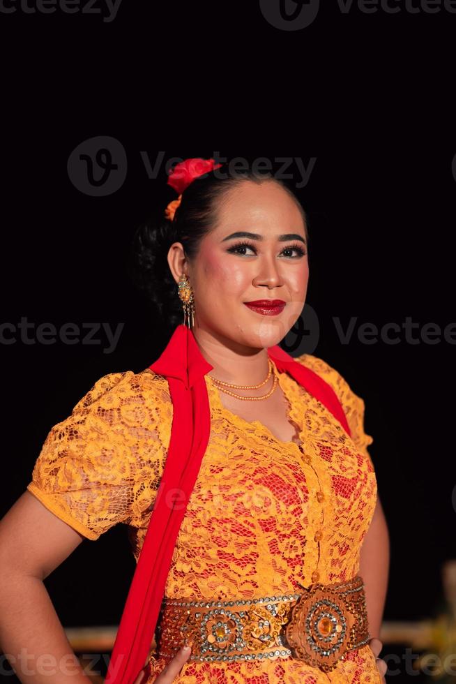 mujeres indonesias exóticas con labios rojos y maquillaje mientras usan un vestido naranja y una bufanda roja foto