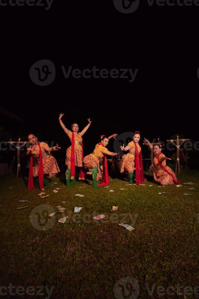 Javanese dancers with beautiful makeup and traditional costume while dancing the traditional dance on the stage photo