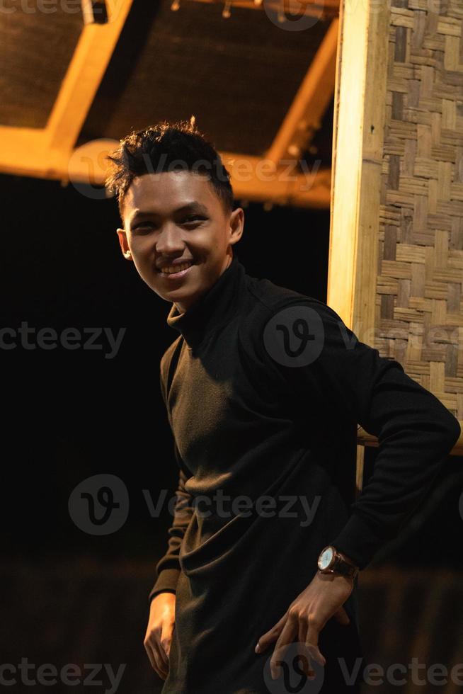 Asian men wearing casual black color clothes inside the wooden house in the dark night photo