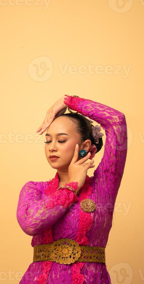 Sexy Asian woman wearing a pink dress called kebaya with a hot pose photo