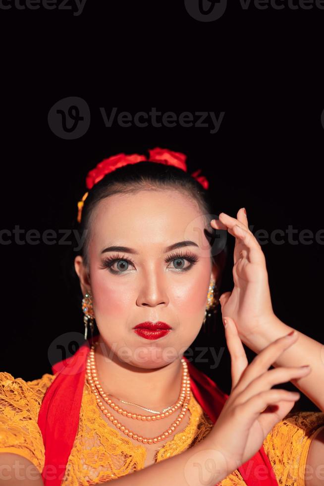Indonesian woman in makeup with red lips wearing a golden necklace and golden earrings photo