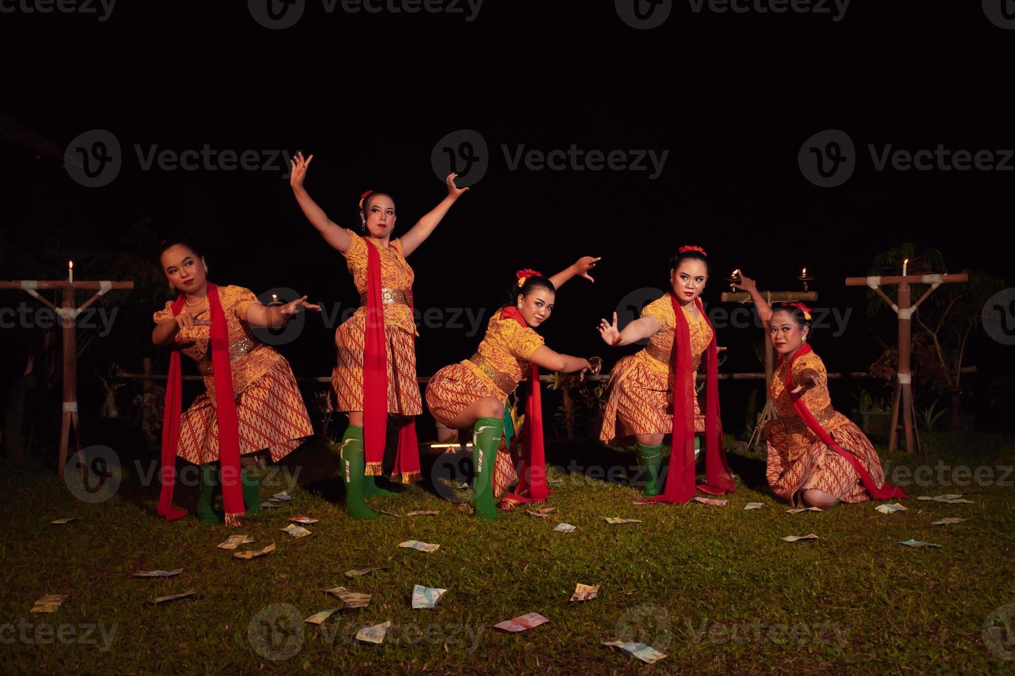 bailarines javaneses con hermoso maquillaje y traje tradicional mientras bailan la danza tradicional en el escenario foto