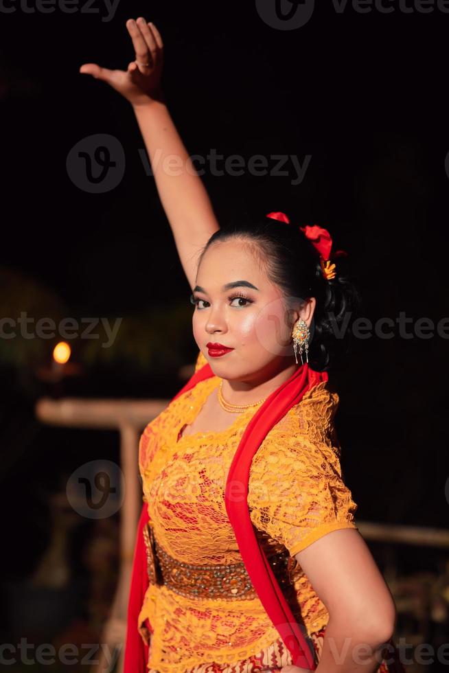 Indonesian women wearing traditional dance costumes called kebaya and pose with dancing moves in the night photo