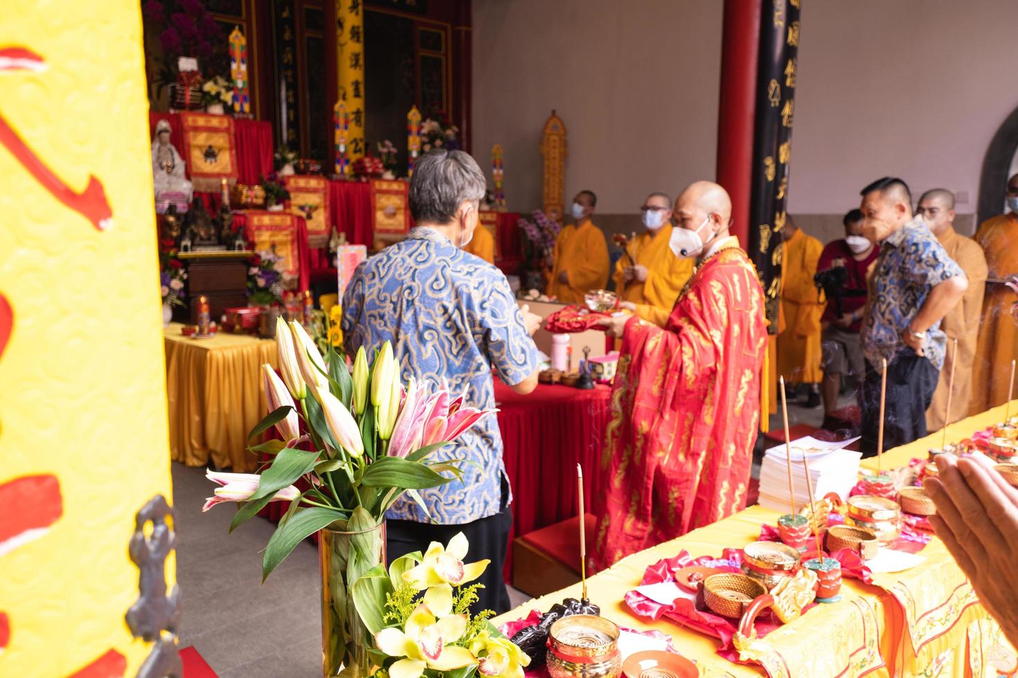 Bandung City, Indonesia, 2022 - The Monks with orange clothes pray together in front of the altar photo