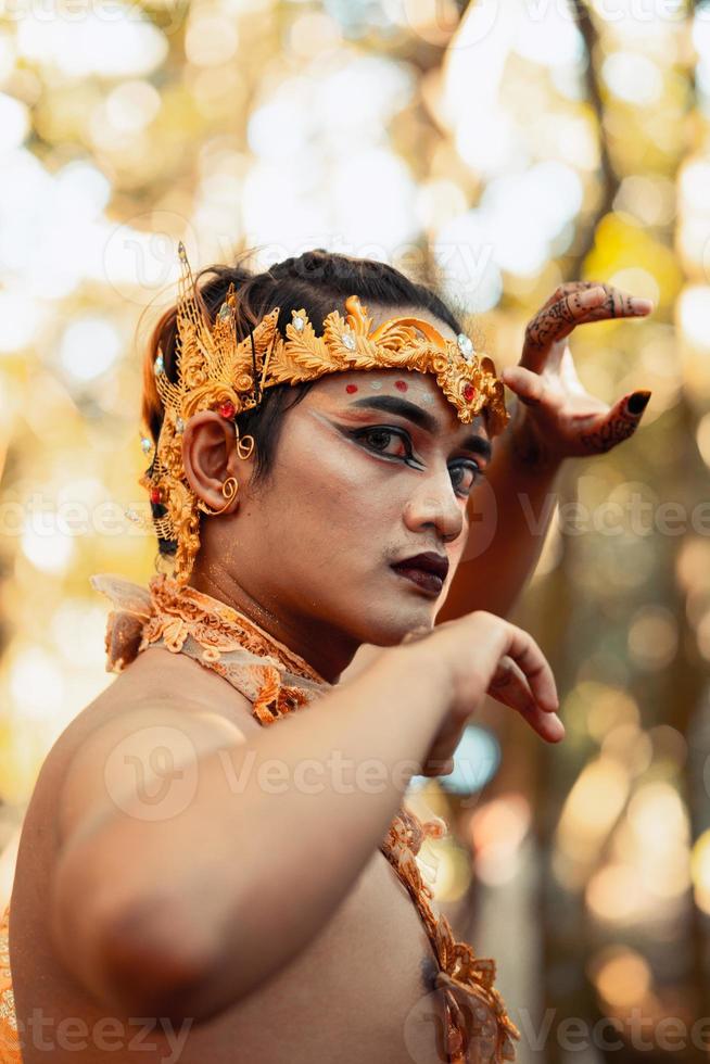 Angry Faces of an Asian man with a golden crown on her head while shirtless and making hands pose photo