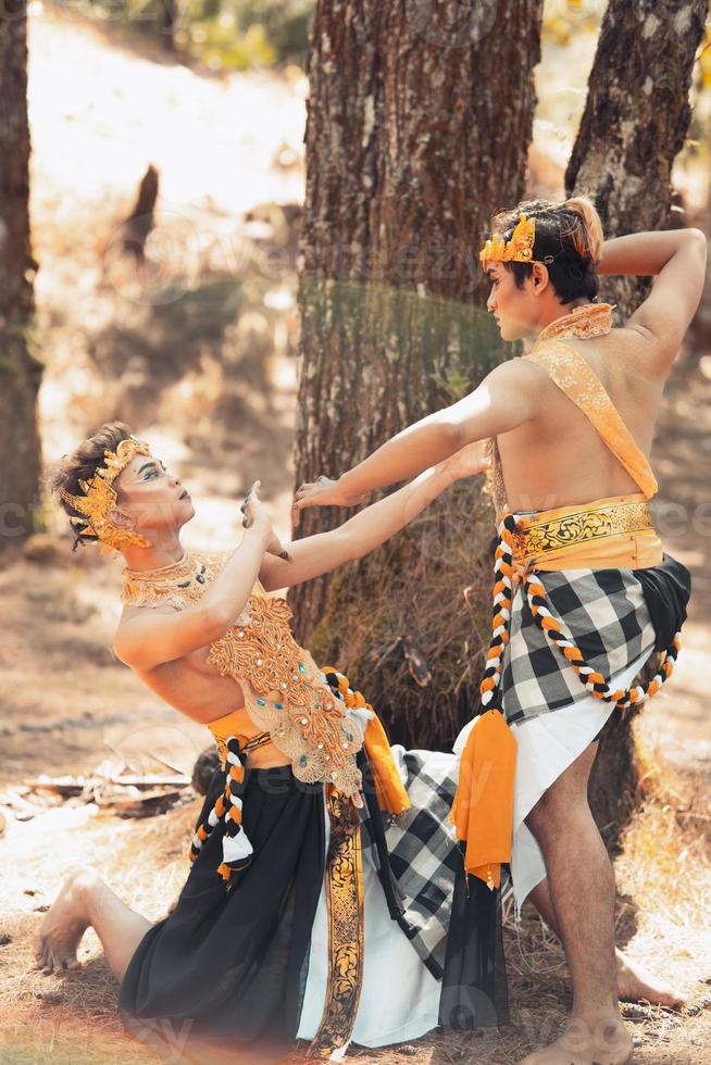 Two Asian men pose together with the gold crown in their hands and wearing striped clothes photo