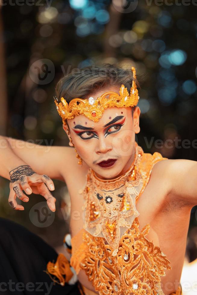 Balinese face in makeup and wearing a golden crown and golden necklace before the dancing performance began photo