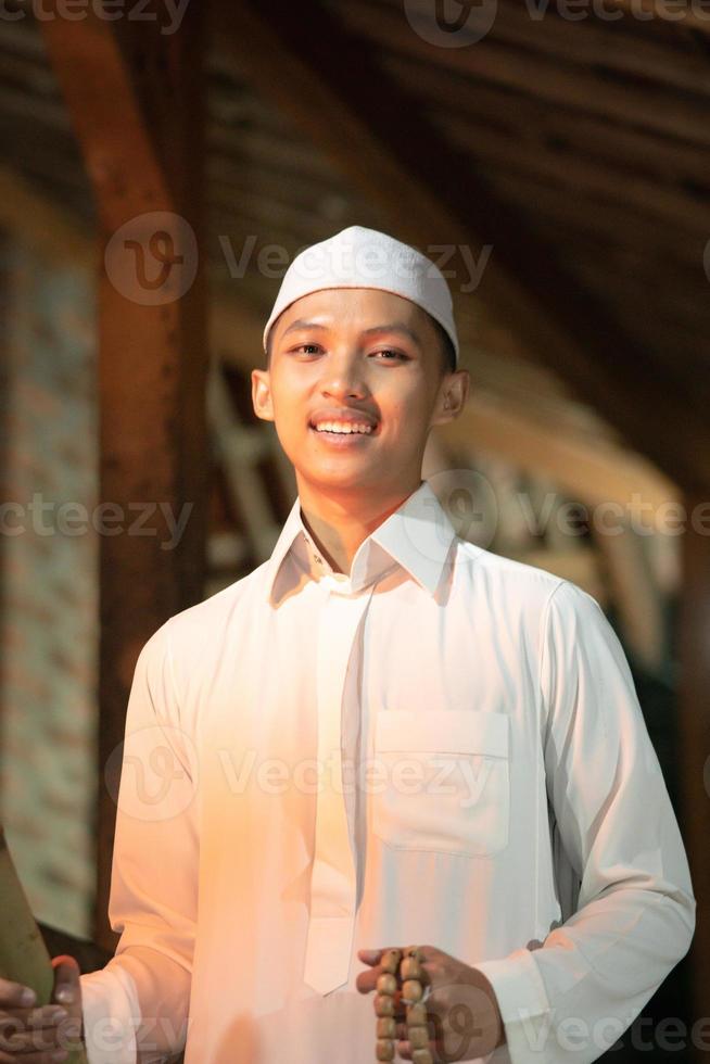 Handsome Islamic man with white Muslim dress in the dark night photo