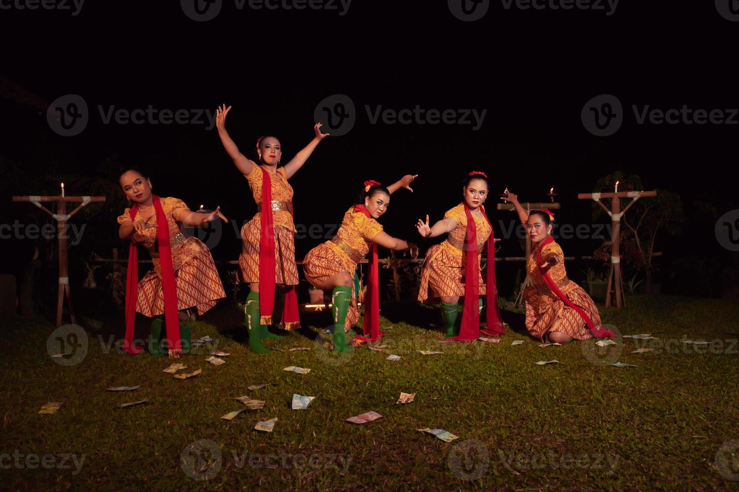 bailarines javaneses con hermoso maquillaje y traje tradicional mientras bailan la danza tradicional en el escenario foto