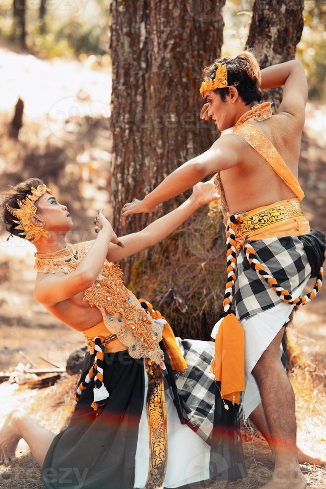 Two Asian men pose together with the gold crown in their hands and wearing striped clothes photo