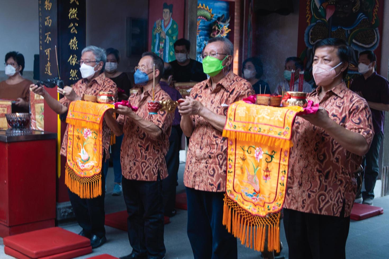 Bandung City, Indonesia, 2022 - The congregation and the monks standing together while praying at the altar to respect the god photo