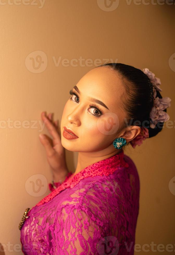 Balinese bride wearing the pink wedding dress before the ceremony has started photo