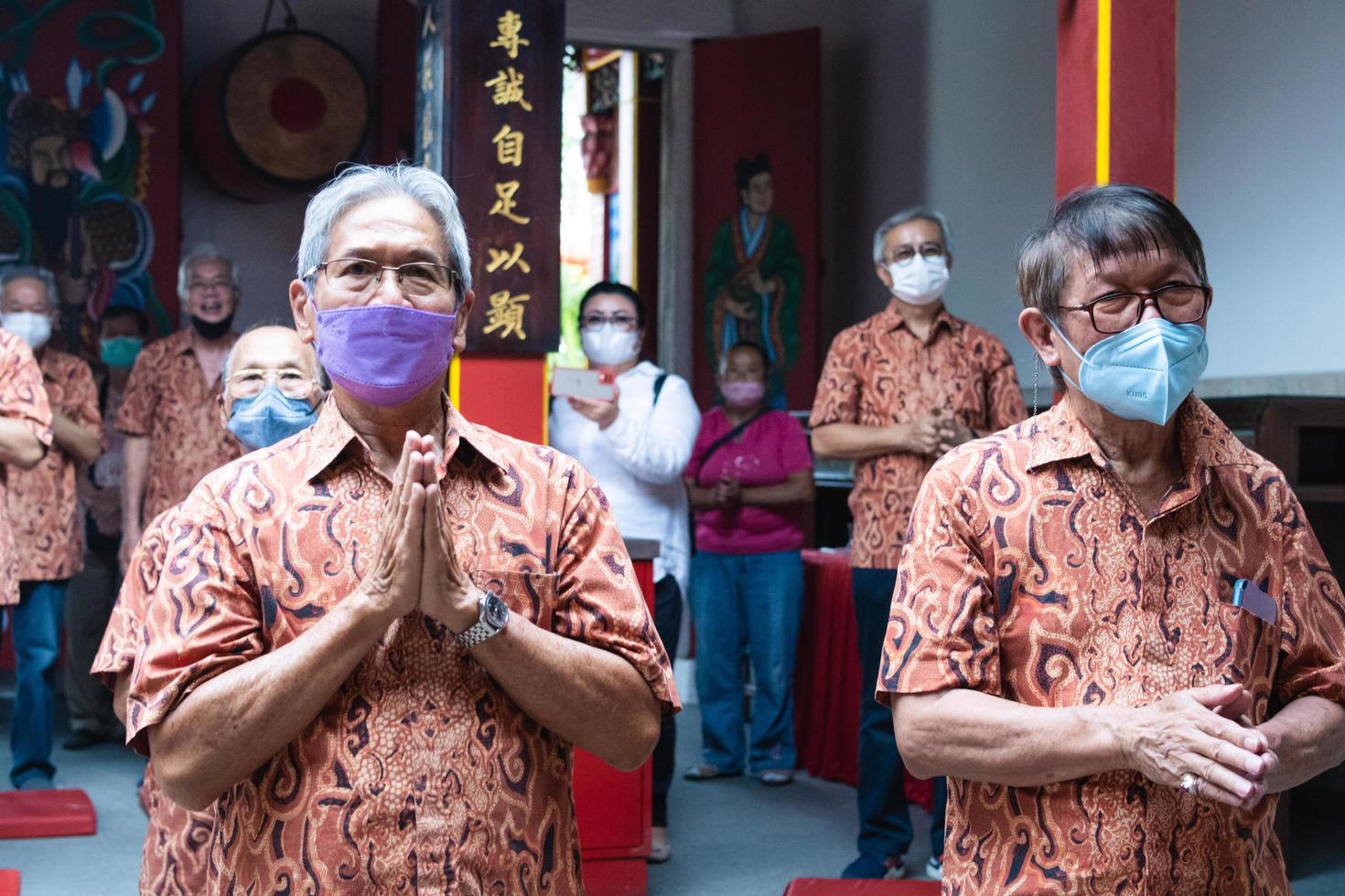 Bandung City, Indonesia, 2022 - Buddhist society walking together for praying at the altar with the monks inside the buddha temple photo