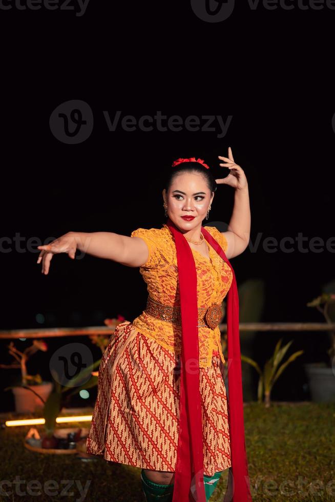 Sundanese woman with an exotic face wearing a yellow dress and red scarf during a dance exhibition photo