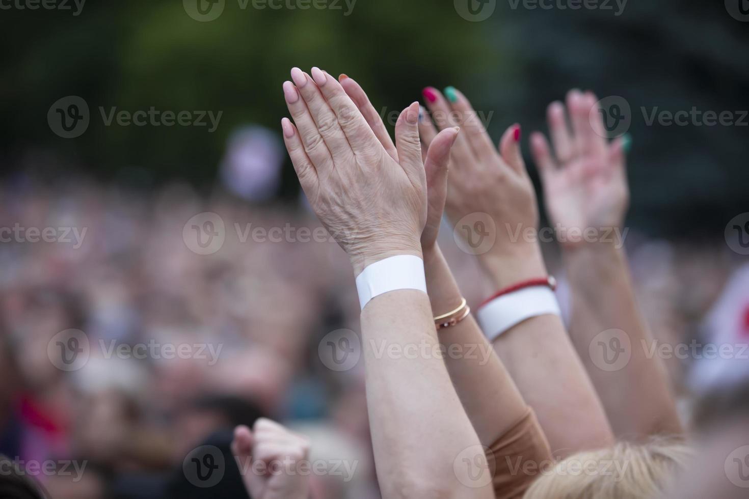 A hand in a fist in protest against a blurred crowd of people. photo