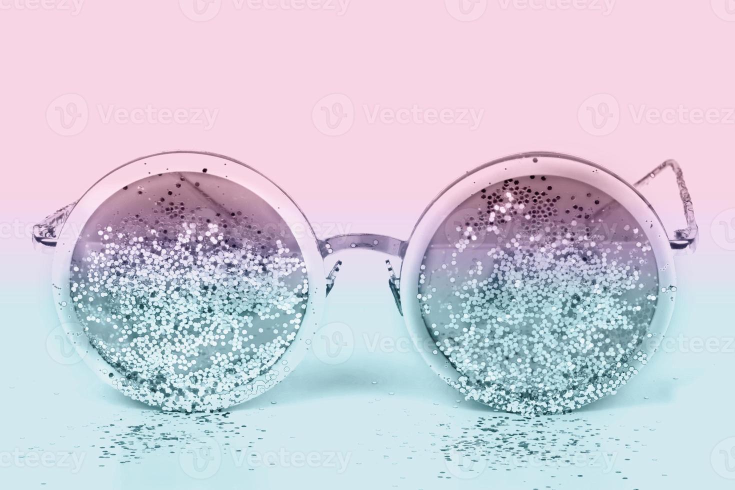 Sunglasses with sparkles on a two-tone background. photo