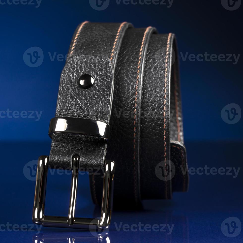 Black leather belt on a dark blue background. photo