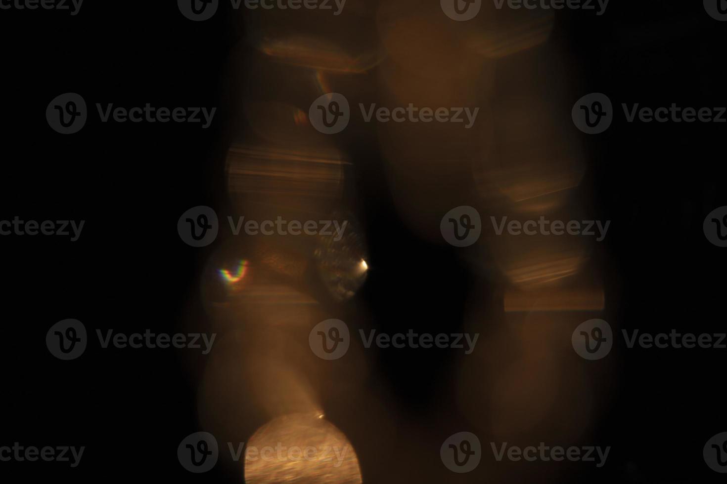 The effect of golden highlights on a black background. Optical glass glare for use in screen mode. Abstract background, flashing iridescent. photo