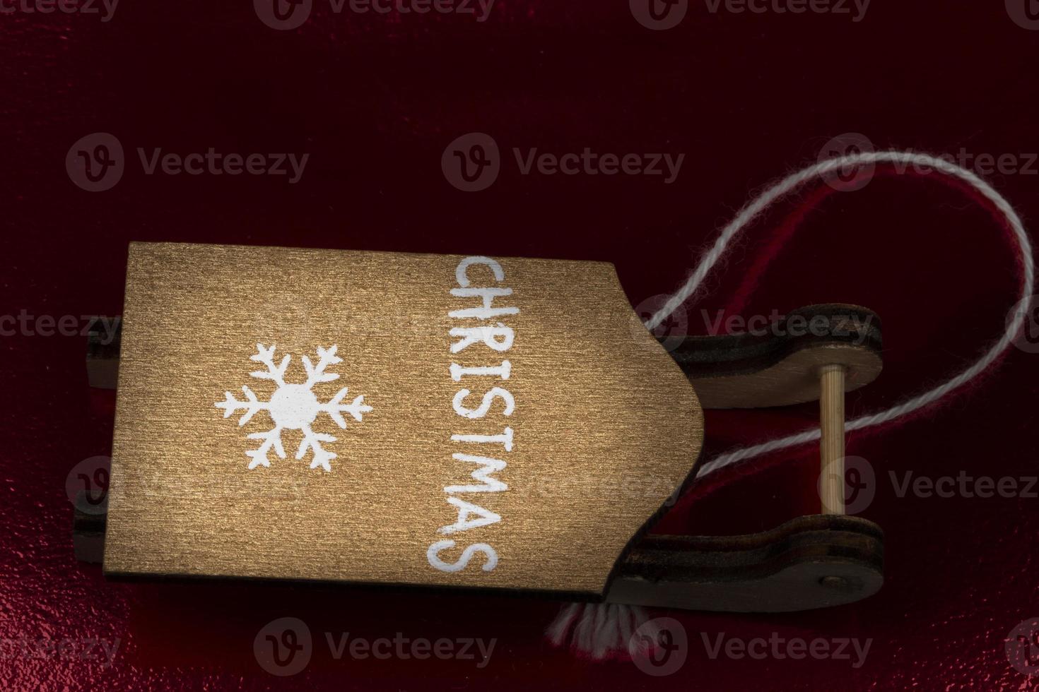 Vintage toy sled made of wood on a dark red background. photo