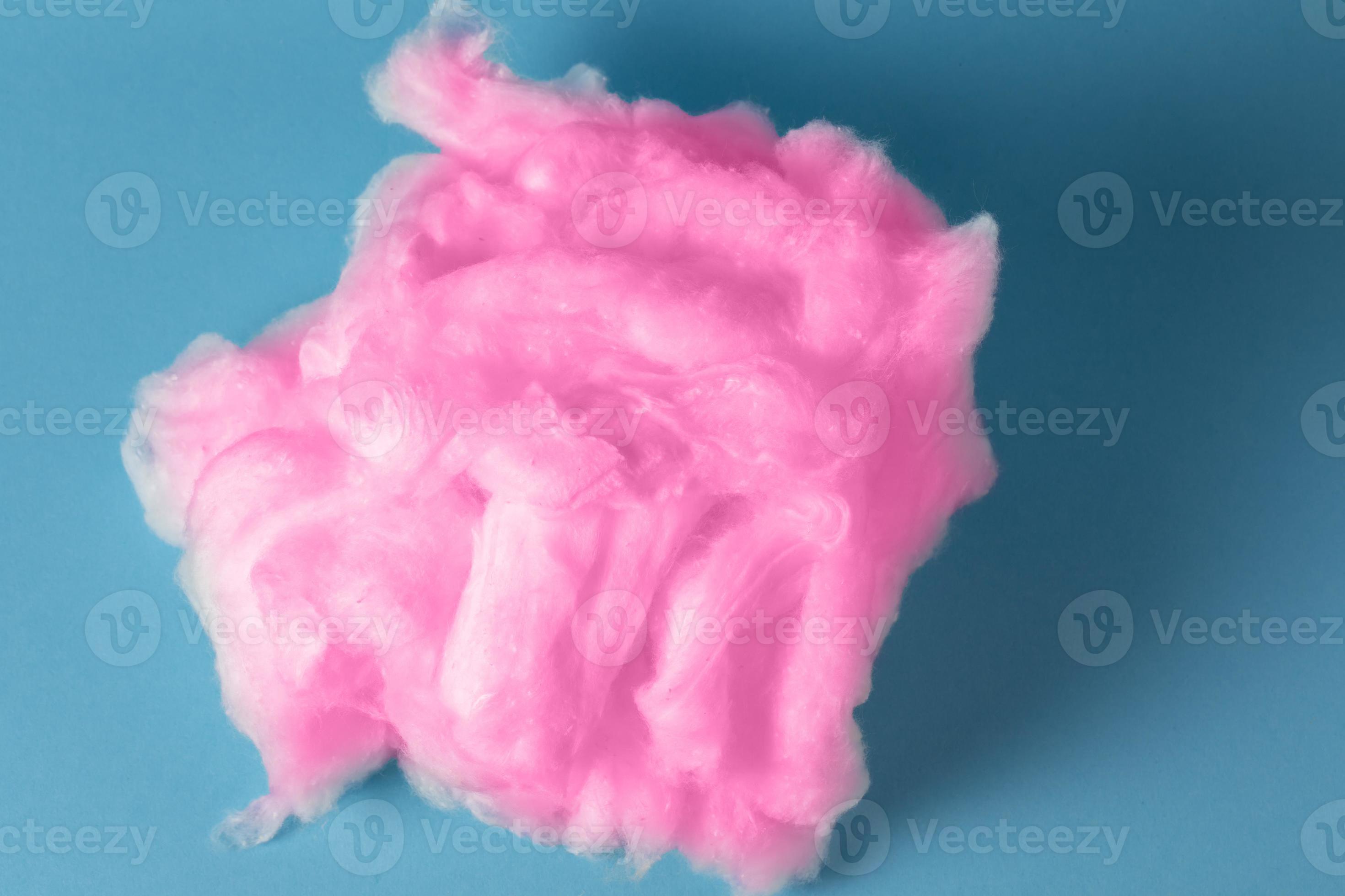 Pink cotton wool on a blue background. A soft pile of fibre.Piece