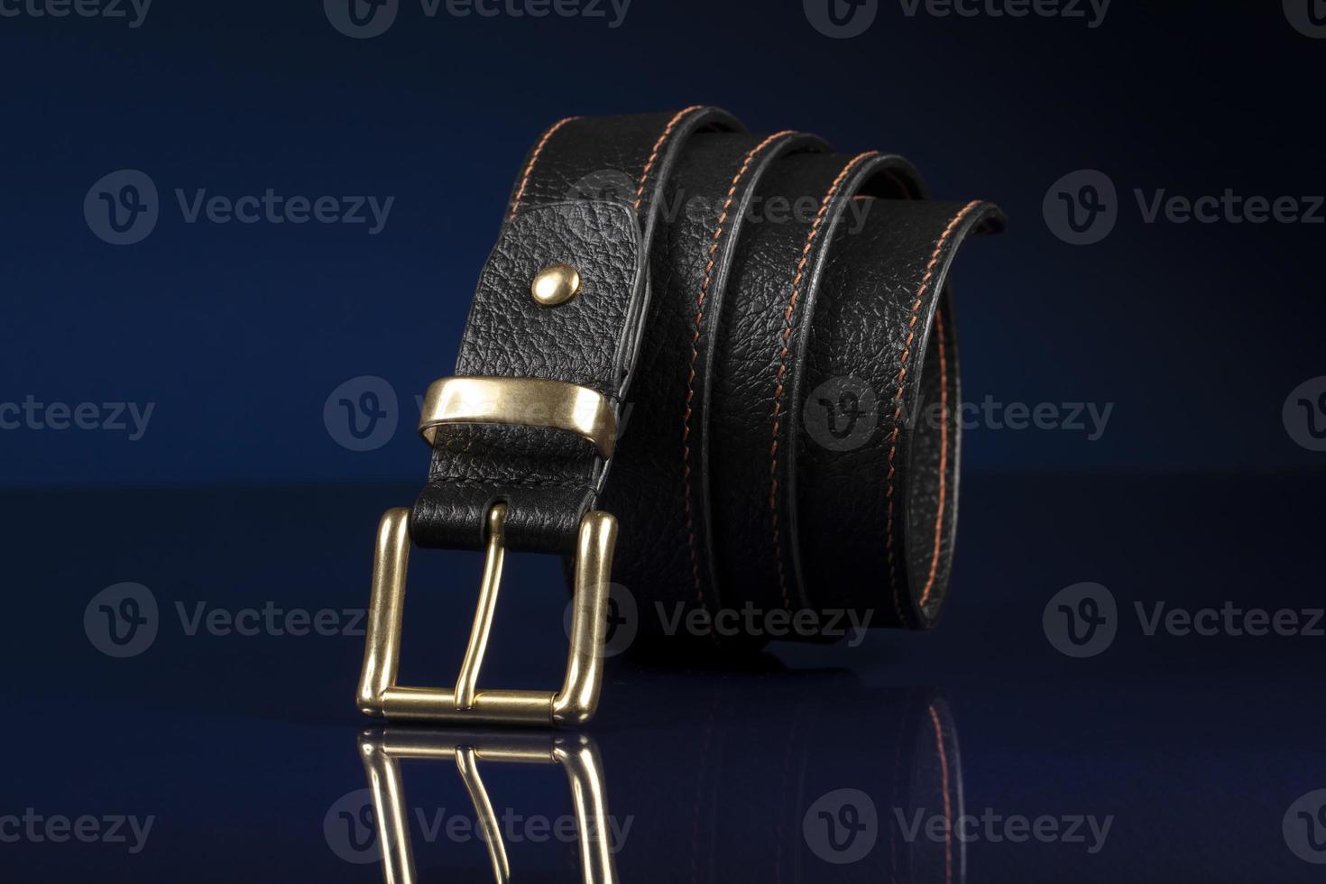 Black leather belt on a dark blue background. photo