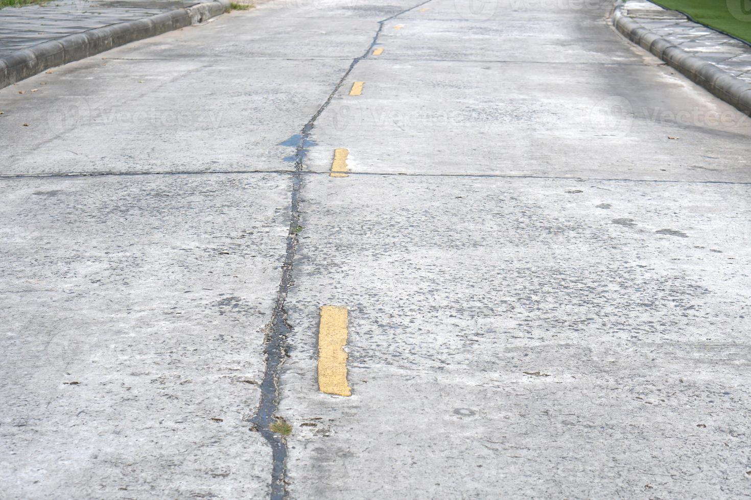 Old road background with yellow lines peeling off from aging. photo