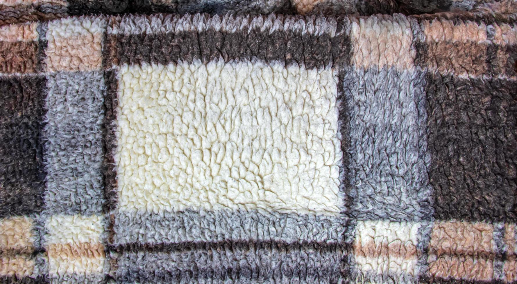Abstract background with geometric pattern of faux fur plush fleece surface close-up. Brown fluffy fabric. photo