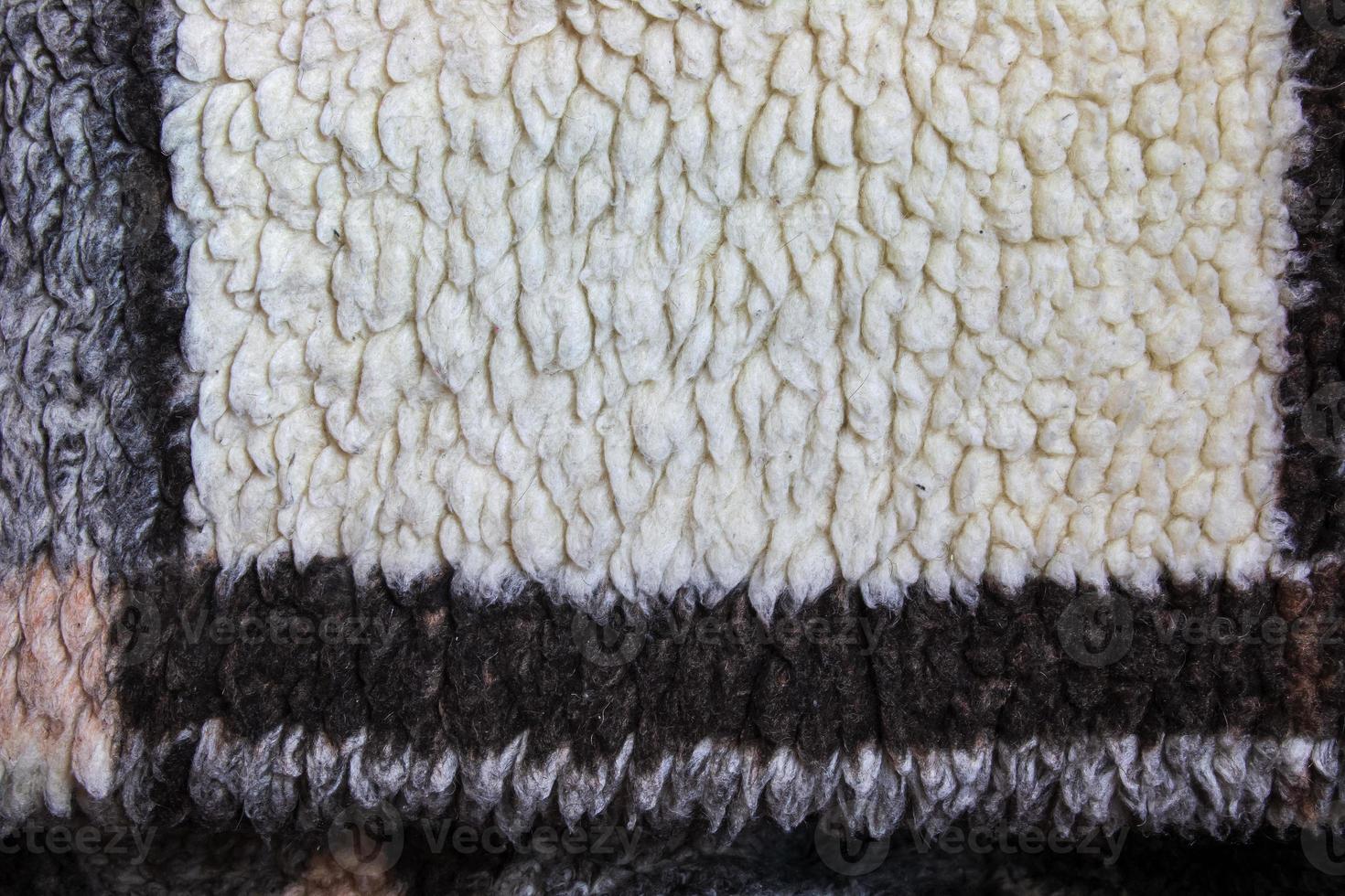Abstract background with geometric pattern of faux fur plush fleece surface close-up. Brown fluffy fabric. photo