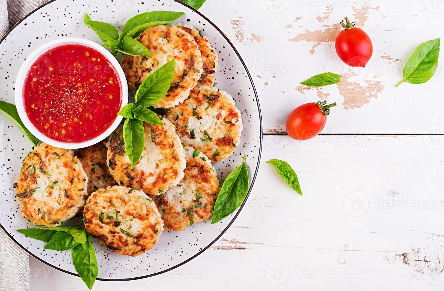 Delicious rice and chicken meat patties with garlic tomato sauce. Top view. Diet food. Copy space photo