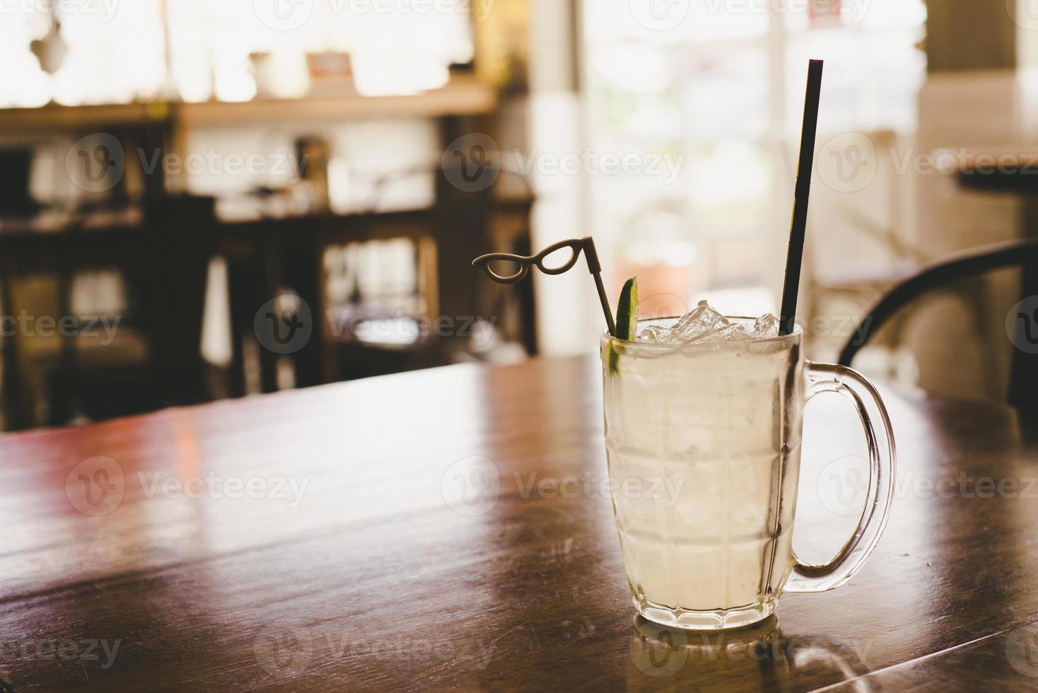 Glass of frozen lemonade with lemon slice on the wooden table photo