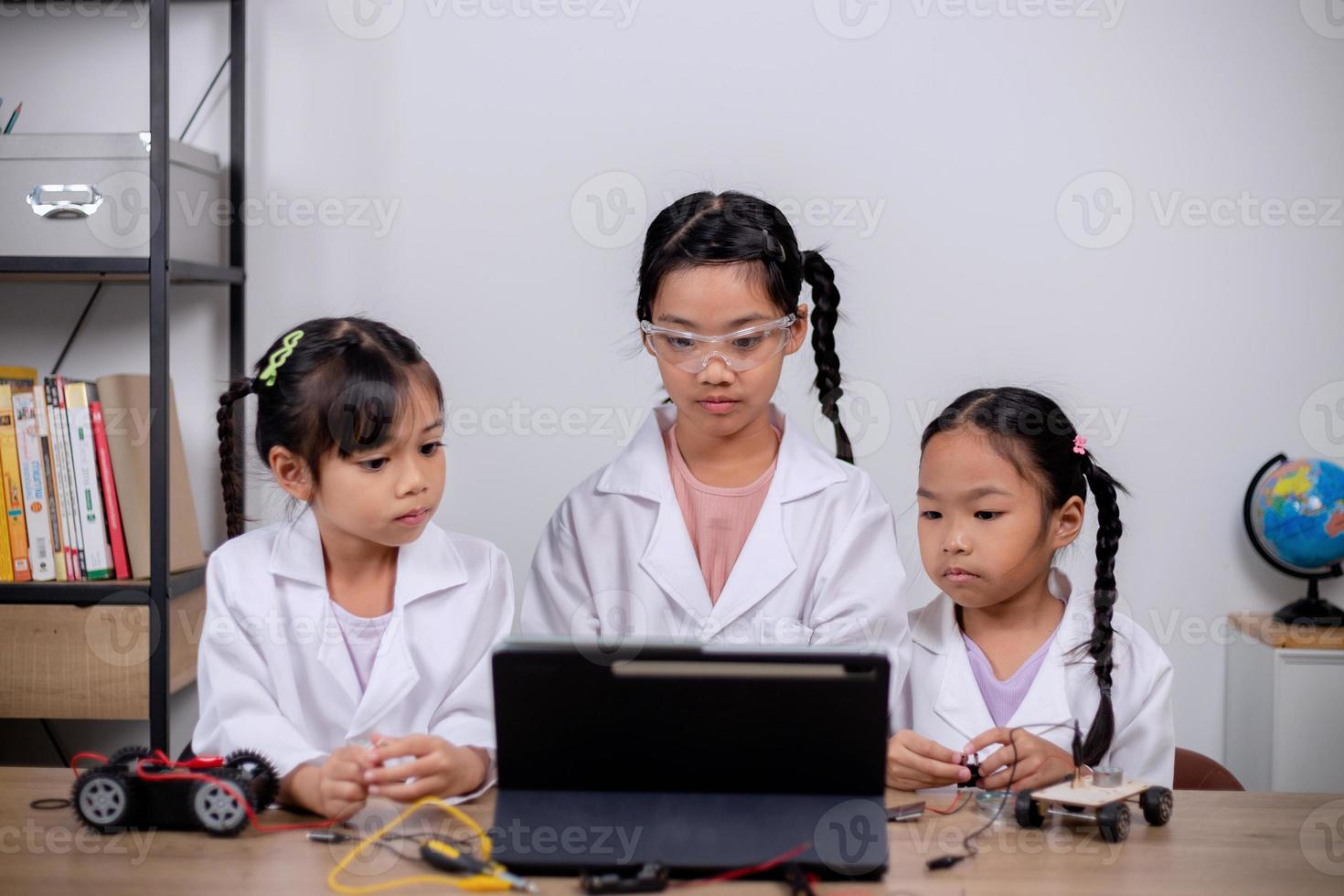 los estudiantes asiáticos aprenden en casa codificando automóviles robot y cables de placas electrónicas en tallo, vapor, ingeniería matemática, ciencia, tecnología, código informático en robótica para conceptos infantiles. foto