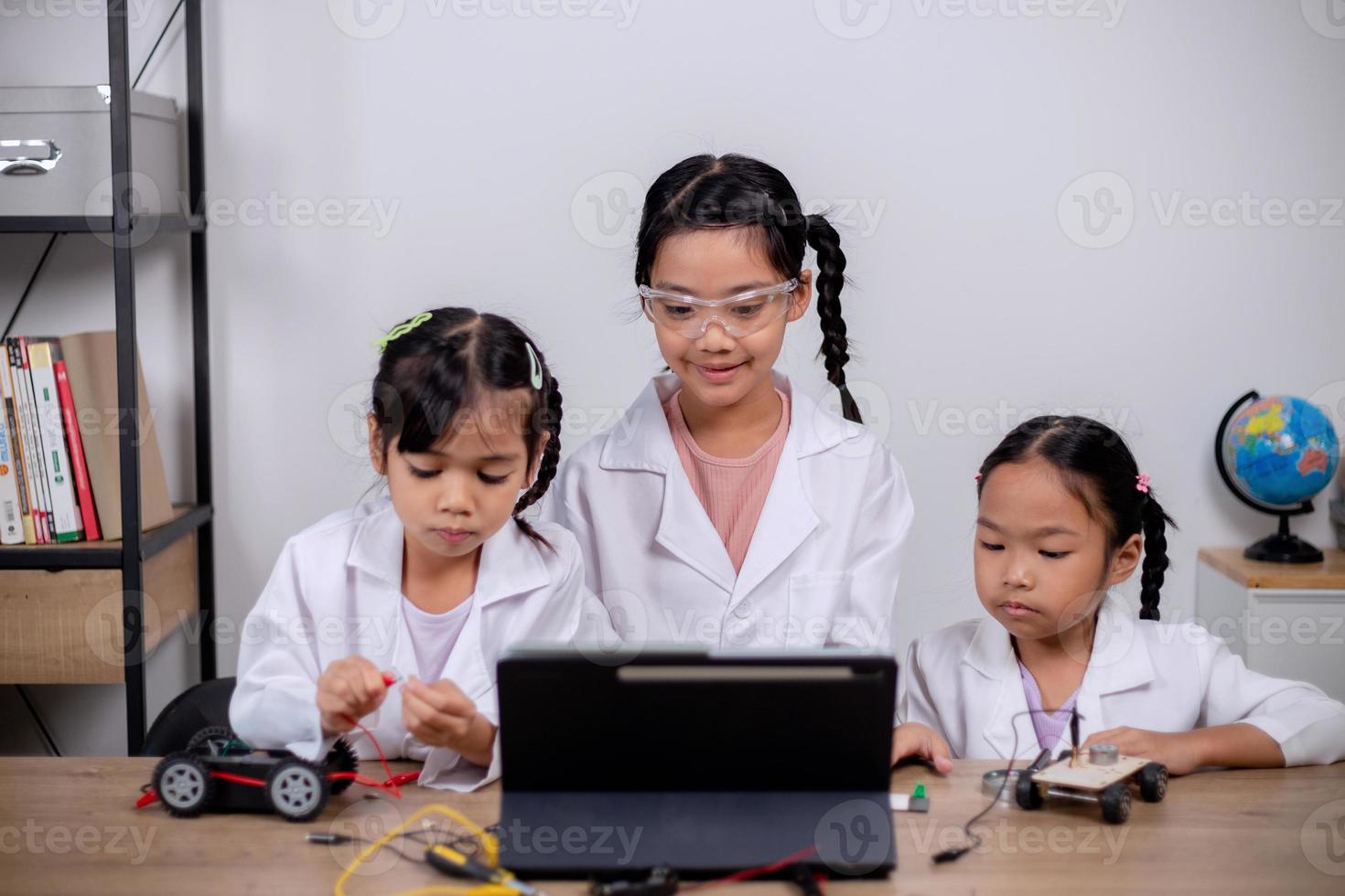 Asian students learn at home by coding robot cars and electronic board cables in STEM, STEAM, mathematics engineering science technology computer code in robotics for kids' concepts. photo