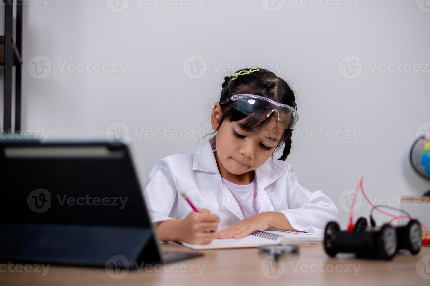 Asian students learn at home by coding robot cars and electronic board cables in STEM, STEAM, mathematics engineering science technology computer code in robotics for kids' concepts. photo