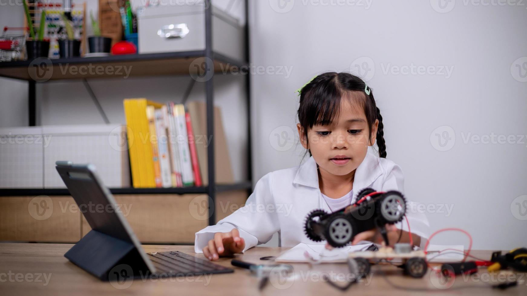 Asian students learn at home by coding robot cars and electronic board ...