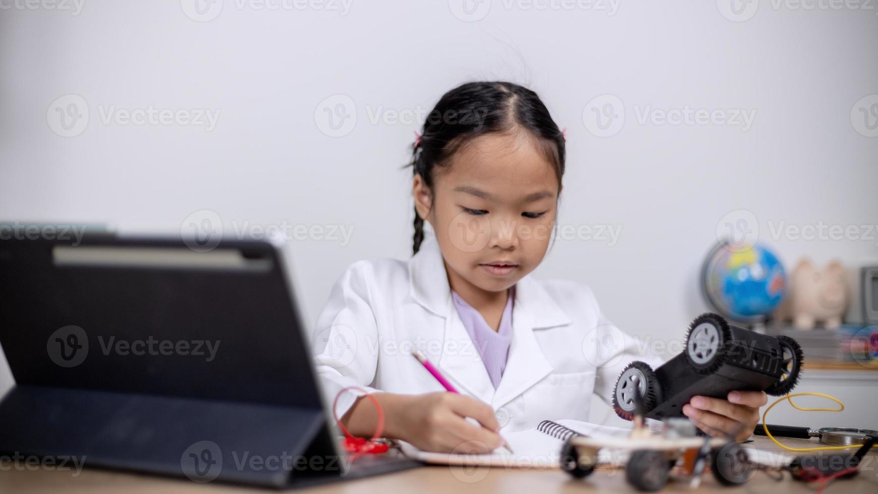 Asian students learn at home by coding robot cars and electronic board cables in STEM, STEAM, mathematics engineering science technology computer code in robotics for kids' concepts. photo